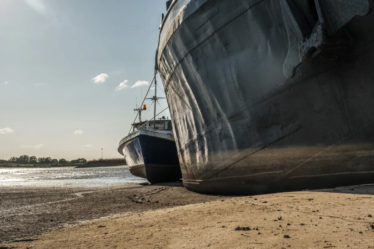 À marée basse, le batelier passe après les digues, la nature et l'eau potable